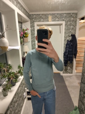 Blågrå bomullströja från Zara - Snygg blågrå långärmad tröja från Zara i 100% bomull. Enkel och stilren design med rund hals och ribbade muddar vid ärmslut och nederkant. Perfekt att matcha med jeans eller chinos för en clean look.