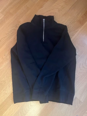 Svart half zip sweatshirt från Zara - Svart sweatshirt med half zip och hög krage. Tröjan har långärmade ärmar och är tillverkad i mjukt material, perfekt för chill dagar. Enkel och stilren design utan synliga loggor eller mönster.