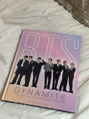 BTS Dynamite: The Story of the Superstars of K-Pop - Upptäck BTS – världens största K-pop-band! Den här boken tar dig med bakom kulisserna till deras resa, prestationer och unika stil. Perfekt för dig som älskar musik, dans och vill veta mer om BTS-medlemmarna och deras framgångar.