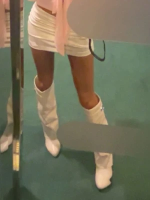 Vita höga boots med metallspänne - säljer ett par snygga höga boots i vit färg, Dom är sparsamt använda i storlek 38. väldigt bekväma💕 Skriv för funderingar eller frågor!