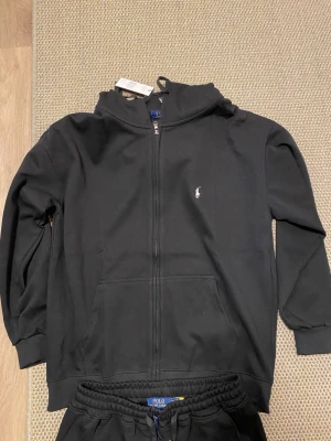 Ralph lauren tracksuit Ny - Ralph lauren tracksuit inga skador eller något fel. den är i ny skick men passa inte mig, finns qr kod i båda plaggen,. Det är 100% bomull. Går mötas upp, och även posta.