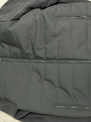 Svart quiltad jacka Massimo Dutti - Säljer en svart quiltad jacka från Massimo Dutti med ribbad krage och två dragkedjeförsedda fickor framtill. Jackan har en stilren look och stängs med dragkedja. Perfekt för dig som gillar en clean och modern stil. Den är XL men passar riktigt bra som L.