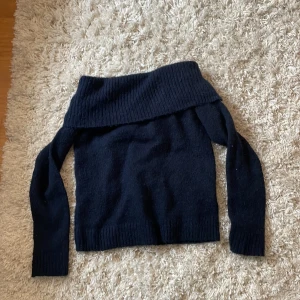 Mörkblå offshoulder stickad tröja från Gina Tricot - Säljer en mörkblå stickad offshoulder-tröja från Gina Tricot. Tröjan har bred ribbad kant upptill som kan bäras offshoulder och långa ärmar. Säljer för att den har ett sticksigt material och har rätt så känslig hud och därmed inte så skön för min hud. Perfekt för dig som vill ha en trendig och mysig look. Orginalpris ca 250kr. Pris kan diskuteras 