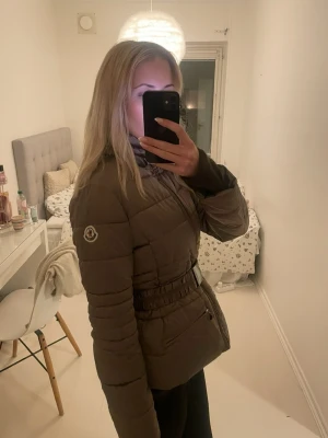 Moncler pufferjacka med bälte - Supersnygg brun/beige pufferjacka från Moncler med markerad midja och bälte. Perfekt till vinter, höst och vår. Köpt på vinted så har  ej kvitto eller bevis. 