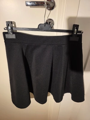 Svart minikjol från H&M - Skaterkjol med textur och dragkedja baktill. Köpt för några år sedan, knappt använd. 