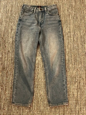Lee  jeans  -  Blå jeans från Lee, modell Carol, Lee-logga på bakfickan. Jeansen har hög midja och raka ben, tillverkade i slitstarkt bomullsmaterial. 