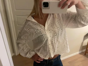Vit broderad skjorta/blus - Supersöt vit broderad skjorta/ blus. Endast använd några gånger. Finns en matchande minikjol till. (Ska strykas innan den skickas)