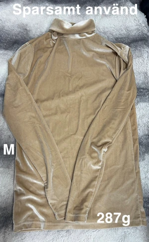 Beige polotopp i sammet M - Säljer en beige polotopp i mjuk sammet. Toppen har långa ärmar och en klassisk polokrage, perfekt för att ge en chill men ändå snygg vibe. Passar dig som gillar neutrala färger och vill ha något skönt men stilrent.🌸Mjuk och härlig velour. Sparsamt använd. Storlek M