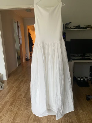 Maxi klänning - Vit maxiklänning från NAKD. Strl 40. Jag är 170cm och den når golvet på mig. Jag har endast provat den så alla lappar sitter kvar. Toppdelen är i viskos och bomull, kjolen i bomull och fodret i polyester. Kjolen har fickor (!!!).  Nypris 799kr. 