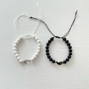 Svart och vitt armband med delfinberlock - ~Yin & Yang Par armband med justerbara band, ett i svart och ett i vitt. Perfekta för att matcha med olika outfits eller ge bort som en vänskapsgåva. De är både stilrena och trendiga!