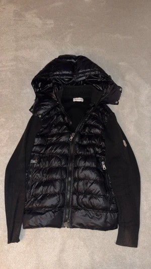 Svart Moncler Cardigan - Svart Moncler Cardigan . Äkta, bra skick! Avtagbar luva och inga skador eller slitningar mm. Skriv om ni har några frågor, priset är inte hugget i sten! 