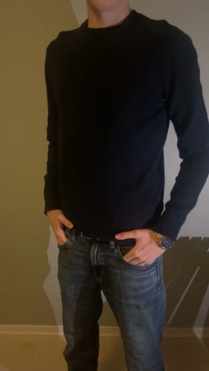 Marin blå stickad tröja - Snygg mörkblå stickad tröja med v-ringad hals som passar till allt. Skick 9/10. Riktigt go passform och den sitter riktigt bekvämt. Perfekt för dig som gillar enkel och stilren look.