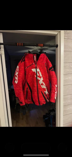 Röd FXR skoter/vinterjacka  - Säljer en röd FXR skoter/vinterjacka då den aldrgi används, använd fåtal gånger så typ nyskick, storlek S men dom som bär m kan lätt ha den. Kanske L oxå.