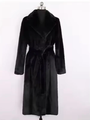 Svart lång pälsjacka med bälte - Säljer en svart lång pälsjacka med bred krage och bälte i midjan. Jackan har en snygg omlottstil och är helsvart med mjukt pälsmaterial. Perfekt för dig som vill ha en riktigt lyxig och varm look under kalla dagar.