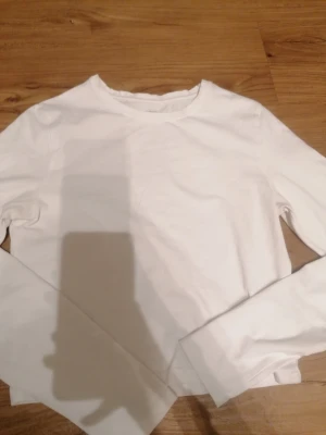 Vit långärmad topp från 157 - Säljer en enkel och stilren vit långärmad topp från 157 i storlek S. Toppen är gjord av mjuk bomull med lite stretch för extra komfort. Passar perfekt till jeans eller kjol och har en klassisk rund halsringning. Den är endast använd två gånger. 😊