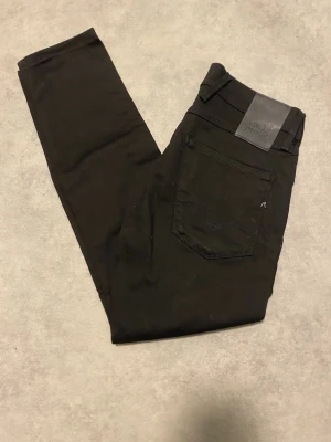 Helt nya Replay Hyperflex svarta jeans Anbass - Svarta Replay Hyperflex Anbass jeans med slim passform och klassisk femficksdesign. Stretchigt material för extra komfort och snygg siluett. Märkespatch i svart läder baktill och diskreta Replay-detaljer på fickorna. Perfekta för dig som gillar stilrena och moderna jeans.