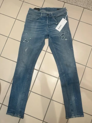 Dondup jeans George - Hej! Säljer dessa HELT nya dondup George jeans köpta på Zgander i Helsingborg. Nypris är som ni ser på bilden precis under 3800kr men mitt pris är endast 899kr priset är fast och ikke diskuterbart och det är först till kvarn som gäller. Superfin och eftertraktad tvätt på jeansen med färgskvätt. W32 längd motsvarar 34 ungefär. Perfekt som julklapp. Skynda fynda denna otroliga rabatten. Handla något mer i min profil och det billigaste plagget blir det 50% på. Vid fler frågor kontakta gärna mig