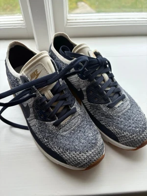 Nike Air Max blå/vita sneakers  - Superfina och sköna par märkeskor från Nike Air Max sneakers i blått och vitt med stickat material med mörkblå detaljer och bruna sulor. Skorna har klassisk Air Max-dämpning, snörning och en sportig vibe. De är i stolek dam 36, bara använda några gånger så i jättebra skick och de är perfekta nu till våren. De är i bra kvalité, är unika och ett perfekt plagg till garderoben då de är enkla att styla🤍Skriv om funderingar, lämnat gärna omdöme & priset kan diskuteras😊
