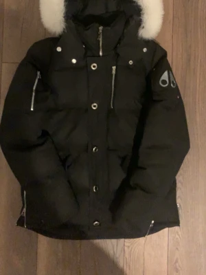 Moose Knuckles Jacka - En moose knuckles jacka Storlek M men hade kunnat passa en storlek S också. Jackan är i helt okej skick finns lite tecken på slitage men inget som syns som man kan se på bilderna. Jag har lagt upp bilder på allt som ska bevisa jackans äkthet . Många kopior har extremt dålig badge och päls men som ni ser på bilderna har jackan Fin päls som känns äkta och badgen är i metall som det ska vara. så säg till om ni funderar något och priset kan diskuteras.