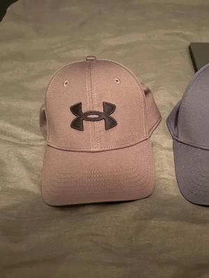 Grå dunväst från Under Armour - Säljer 3 under armour kepsar för ett skit bra pris 3 stycken. Ny pris 299kr styck säljer alla 3 för ett kalas pris