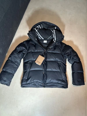 Burberry pufferjacket  - Säljer min oanvända burberry jacka med dust bag och taggen på. I storlek M kommer med nytt skick. Och jackan kan bli till väst genom att ta av armarna.Pris kan diskuteras😊