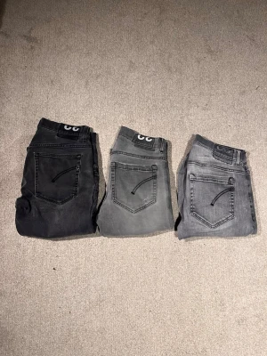 Bulk dondup jeans  - Säljer tre par grå jeans från George i skinny fit, alla i storlek 32. Färgerna varierar från mörkgrå till ljusgrå och de har klassiska femficksdetaljer och svarta sömmar på bakfickorna. Perfekta om du gillar en smal siluett och vill ha olika nyanser av grått i garderoben. Första: 32 Ritchie. Andra: 32 George. Tredje: George 32.