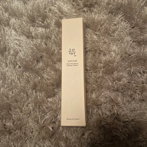 Beauty of Joseon Revive Eye Serum - Revive Eye Serum från Beauty of Joseon med ginseng och retinal. Kommer i en smal, beige förpackning med stilren design och text på både engelska och koreanska. Perfekt för dig som vill boosta huden runt ögonen med aktiva ingredienser.