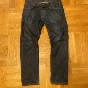 Mörkblå jeans från Nudie Jeans - Snygga Gritty Jackson dry jeans från Nudie. Jeansen är i bra skick och har fått några få snygga fades. Vid fler frågor eller bilder är det bara att höra av sig! Pris kan diskuteras