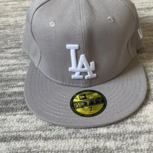 Grå LA keps - Säljer en grå LA keps i storlek 7 som motsvarar 55 cm  kan oxå gå ner o pris.