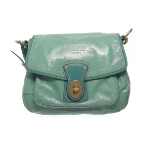 Coachväska - Snygg turkos axelväska från Coach i äkta skinn med justerbar rem och guldfärgade metalldetaljer. Väskan har lock med vridspänne och dekorativa sömmar. Går ner en liten dator samt annat man behöver. Köpt för 920 på sellpy, så den är äkthetsverifierad! Skriv privat för mer info!💓