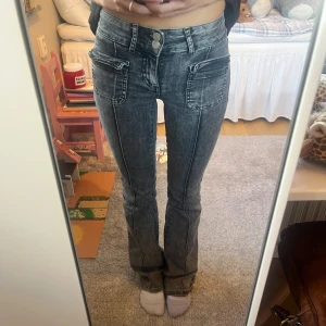 Grå bootcut jeans från Nelly - Snygga  jeans från Nelly! Jeansen är slitna längst ner vid benen, se bild!