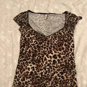 Leopardmönstrad topp från Nelly - Snygg leopardmönstrad topp från Nelly med v-ringning och korta ärmar. Toppens material är mjukt och stretchigt