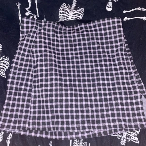 Lila och svart rutig kjol Divided - Kort kjol från Divided by H&M i lila och svart rutigt mönster. Kjolen har en klassisk A-linjeform och är gjord i mjuk polyesterblandning med stretch. Perfekt för dig som gillar en edgy och trendig stil.