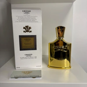 Creed Millésime Impérial 100ml Parfym - Lyxig parfym från Creed, Millésime Impérial, i en snygg guldfärgad metallflaska på 100 ml. Flaskan har en exklusiv design med präglad logga och levereras i en elegant vit kartong med gulddetaljer. Perfekt för dig som gillar exklusiva dofter och stilren design.