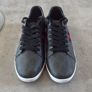 Gucci svarta sneakers med GG-mönster - Hej säljer nu mina Gucci skor i storlek 45. Aldrig använda helt nya. Dom är i riktigt bra skick. Pris kan diskuteras.