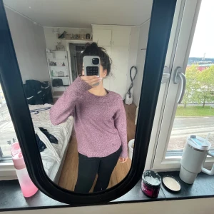 Lila stickad tröja från Vero Moda - Mysig lila stickad tröja från Vero Moda i storlek M. Tröjan har rund halsringning och långa ärmar, perfekt för lager-på-lager under kyligare dagar. Enkel och stilren design som är lätt att matcha med olika outfits.