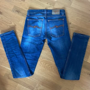 Blå Nudie Jeans - (Ge prisförslag) Snygga blå jeans från Nudie jeans i riktigt bra skick med lite små slitningar. Storleken är w26 l32 och modellen är tight long john som är slim fit. Hör gärna av dig vid frågor eller funderingar!😁