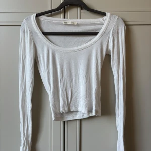 Vit ribbad croppad långärmad topp - Säljer denna vita ribbade långärmade toppen från Stradivarius.🥰Använd ett fåtal gånger.