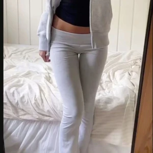 Ljusgrå bootcut mjukisbyxor - Supersköna ljusgrå mjukisbyxor med bootcut och låg midja. Byxorna är i mjukt bomullsmaterial och har en bred linning som ger en snygg siluett. Perfekta för chill dagar eller när du vill ha en avslappnad look.