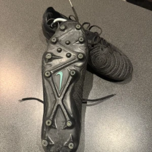 Svarta Nike fotbollsskor Elite skor storlek 42 - Säljer ett par svarta Nike fotbollsskor med stickad ovandel och klassisk snörning. Storlek 42 det är elite skor. 