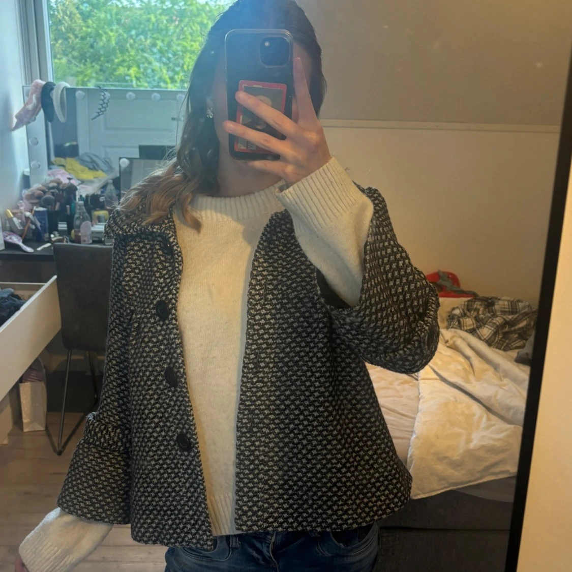 Svartvit mönstrad kappa med stora knappar