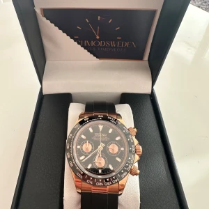 Seiko kronograf svart och guld - Snygg Seiko kronograf med svart urtavla och detaljer i guld. Klockan har tre mindre urtavlor, svarta och guldiga visare samt svart armband. Perfekt accessoar för dig som gillar stilren och lyxig design. Vattentålig går basta med klockan lyser i mörkret visarna också