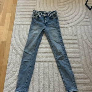 Blå skinny jeans med normal midja - Snygga blå jeans med skinny passform och klassisk femficksdesign. Jeansen har normal midja och är tillverkade i mjukt denim-material. Perfekta för dig som gillar en smal siluett och stilren look.