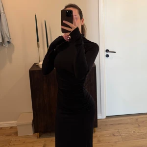 Svart tight klänning med polokrage - Svart, åtsittande klänning med polokrage. Rynkad i midjan. Slits. Använd 1 gång.