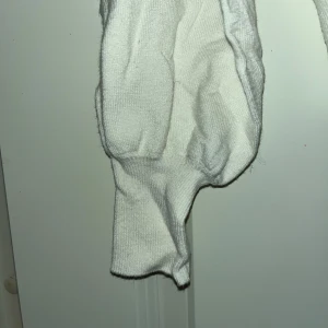 Vit stickad tröja från ONLY - Vit stickad tröja från ONLY i storlek S. Tröjan har rund halsringning, ribbade muddar vid ärmslut och nederkant samt långa ärmar. Enkel och clean design som är lätt att matcha med olika outfits.Den är lite nopprig men inget som stör 