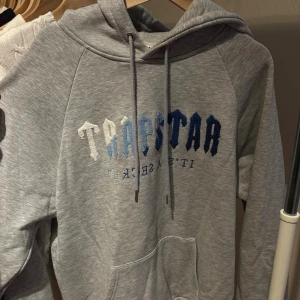 Trapstar Hoodie - Säljer en grå hoodie från Trapstar i storlek XL men passar person i Large också, har använt fåtal gånger men ser ut precis som ny! Vill bara bli av med den då jag inte gillar stilen så mycket!