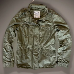 Field jacket olivgrön  - Stilren och trendig perfekt nu i det kylliga vädret. Bra skick! C=41cm D=61cm. Skriv vid fundering 👋😊