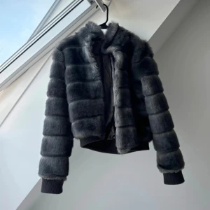 Grå pälsjacka med ribbade muddar - Säljer en jättesnygg, cool jacka!!Det går att stänga jackan med krockarna. Perfekt nu när de börjar bli ännu lite kallare ute🙏😊Skriv gärna frågor!