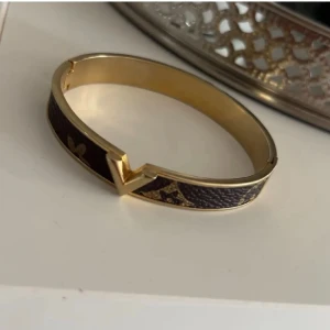 Fint guld Armband - Fint guld armband med brunt, använt men fortfarande i bra skick som syns!