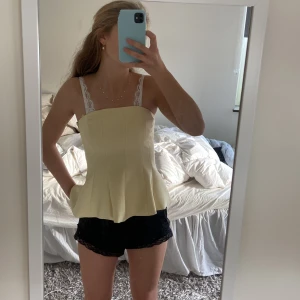 Gul korsett-topp från Zara XS - Säljer en ljusgul korsett-topp från Zara i storlek XS. Toppen har en figurnära passform . Materialet är mjukt och syntetiskt, perfekt för att skapa en trendig look. Aldirg använd
